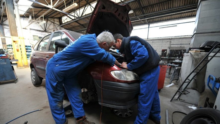 Un mécanicien et un apprenti travaillent dans un garage à Hérouville-Saint-Clair, dans le Calvados, le 24 avril 2008