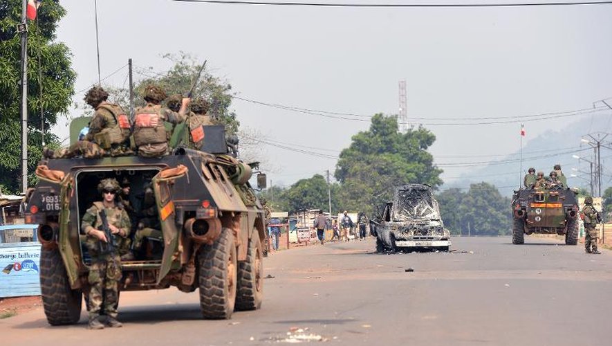 Des soldats français près du véhicule calciné de soldats tchadiens de la Misca, le 26 décembre 2013 à Bangui