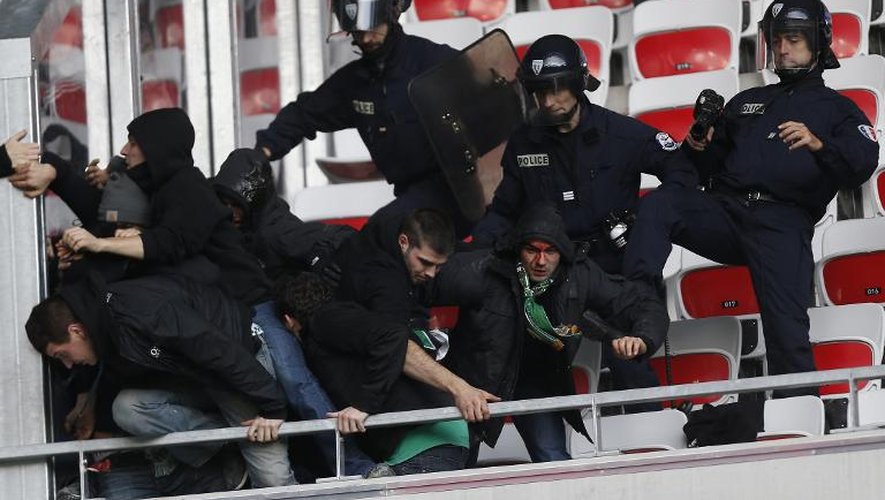 Des supporters évacués par des CRS avant le début du match de Ligue 1 Nice-Saint-Etienne, à l'Allianz-Riviera, le 24 novembre 2013 à Nice