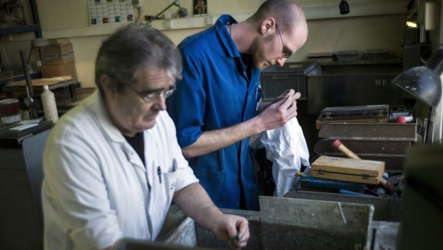 Un jeune homme, alors employé avec un contrat de génération, travaille aux côtés d'un employé plus âgé, le 25 mars 2013 dans un atelier d'assemblage d'optique à Mitry-Mory, en Seine-et-Marne