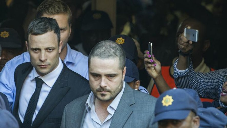 Oscar Pistorius (G) à la sortie du tribunal le 11 septembre 2014 à Pretoria