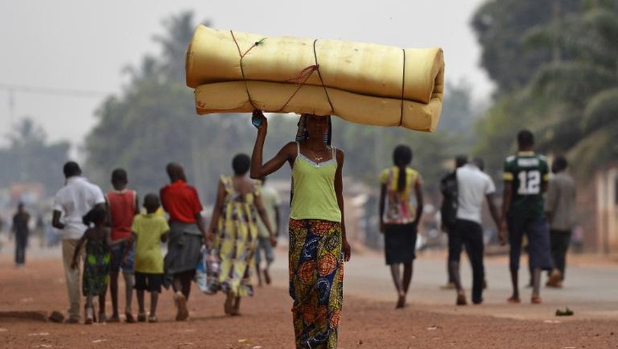 Une femme transportant un matelas sur sa tête fuit le quartier Gobongo de Bangui le 26 décembre 2013