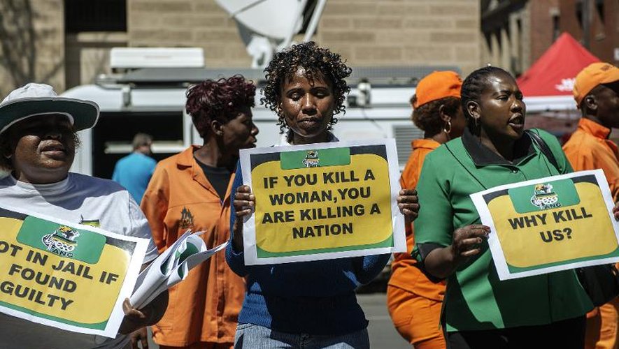 Des militantes de la Ligue des femmes de l'ANC brandissent des pancartes avec le slogan "Si vous tuez une femme, vous tuez une Nation", devant le tribunal de Pretoria pendant le procès de Pistorius le 11 septembre 2014