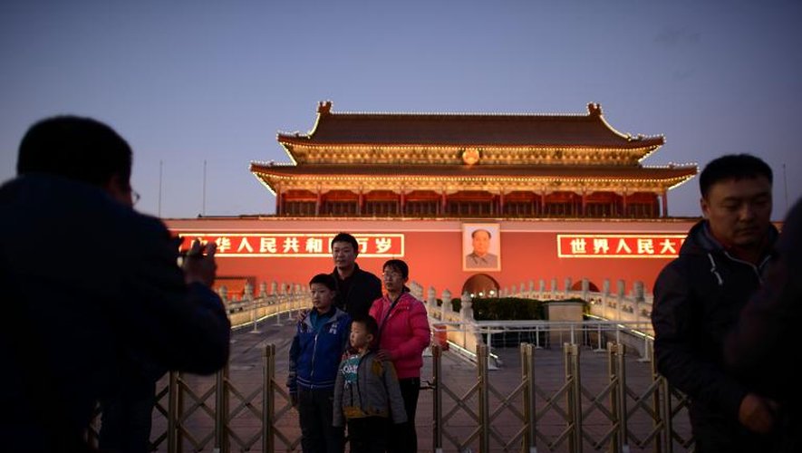 Une famille chinoise pose le 17 novembre 2013 place Tiananmen à Pékin