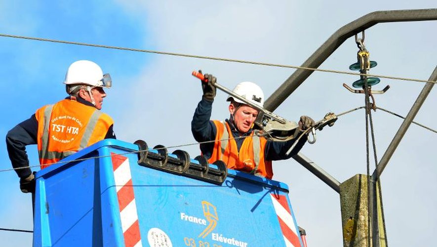 Des agents ERDF réparent une ligne électrique sur un pilône après le passage de la tempête Dirk, le 26 décembre 2013