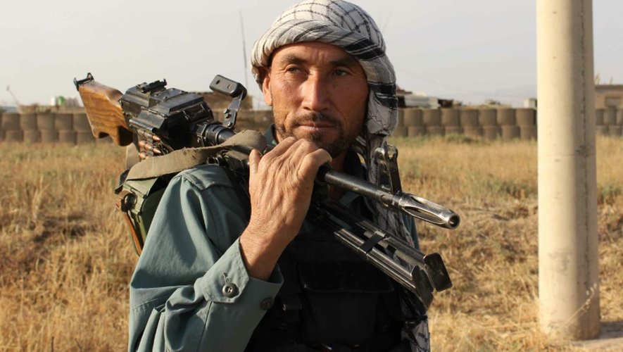 Un policier afghan porte son arme sur l'épaule près de la ville de Kunduz, aux mains des talibans, le 29 septembre 2015