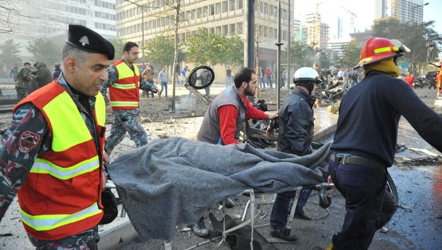 Les forces de sécurité emportent sur une civière l'attentat à la voiture piégée commis le 27 décembre 2013 à Beyrouth