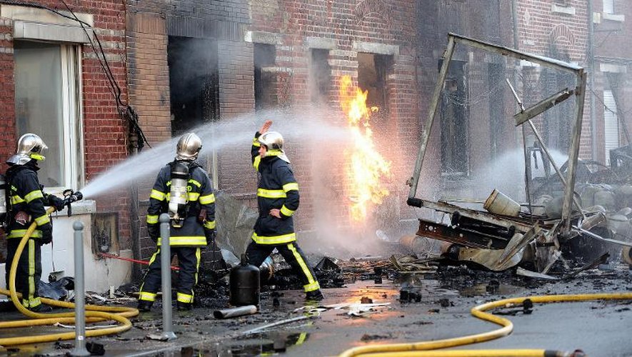 Des pompiers éteignent un incendie provoqué par un camion transportant des bouteilles de gaz, le 28 décembre 2013 à Lomme, près de Lille