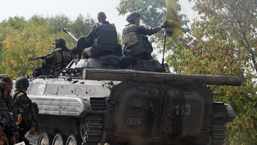 Des soldats ukrainiens en patrouille à bord d'un char près de Popasna, dans la région de Lougansk, le 12 septembre 2014