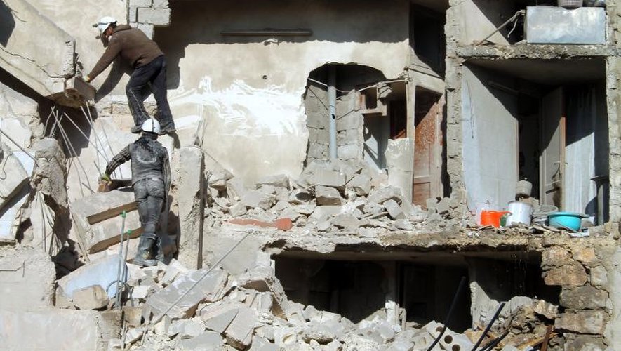 Des sauveteurs dans les décombres d'un immeuble bombardé par l'aviation syrienne, le 24 décembre 2013 à Alep
