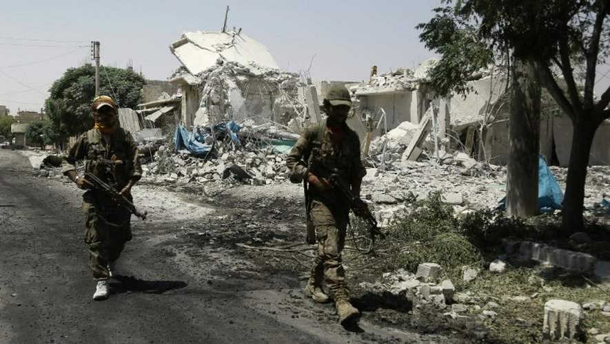 Des membres des Forces démocratiques syriennes (SDF) patrouillent parmi les décombres dans la ville de Minbej (nord de la Syrie) le 7 août 2016 recherchant les derniers jihadistes