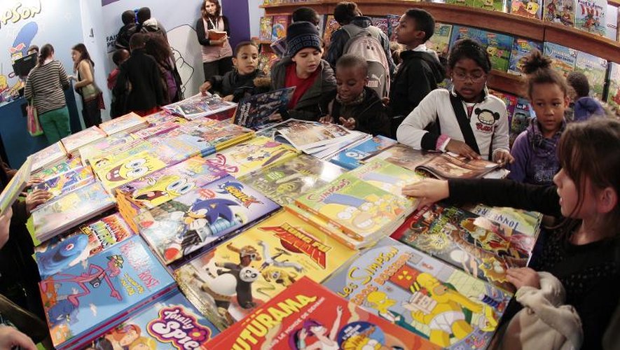 Des enfants consultent des bandes dessinées, le 25 novembre 2009, au premier jour du 25e salon du Livre et de la presse jeunesse de Montreuil