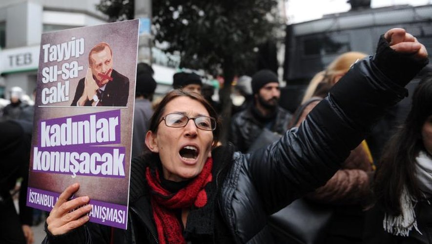 Une femme tient une pancarte avec une photo du Premier ministre turc Recep Tayyip Erdogan, sur laquelle est écrit "Tayyip, vas-tu te taire! et laisser les femmes faire" lors d'une manifestation contre le gouvernement, le 29 décembre 2013 à Istanb