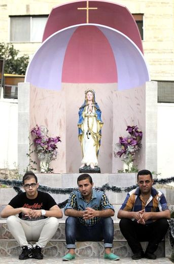 Des chrétiens d'Irak, réfugiés en Jordanie après avoir fui Mossoul, sont assis sur les marches d'une église à Amman le 7 septembre 2014
