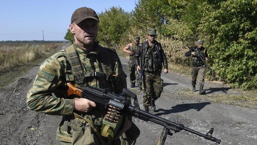 Des rebelles prorusses patrouillent sur une route à Olenivka, à 30 km au sud de Donetsk