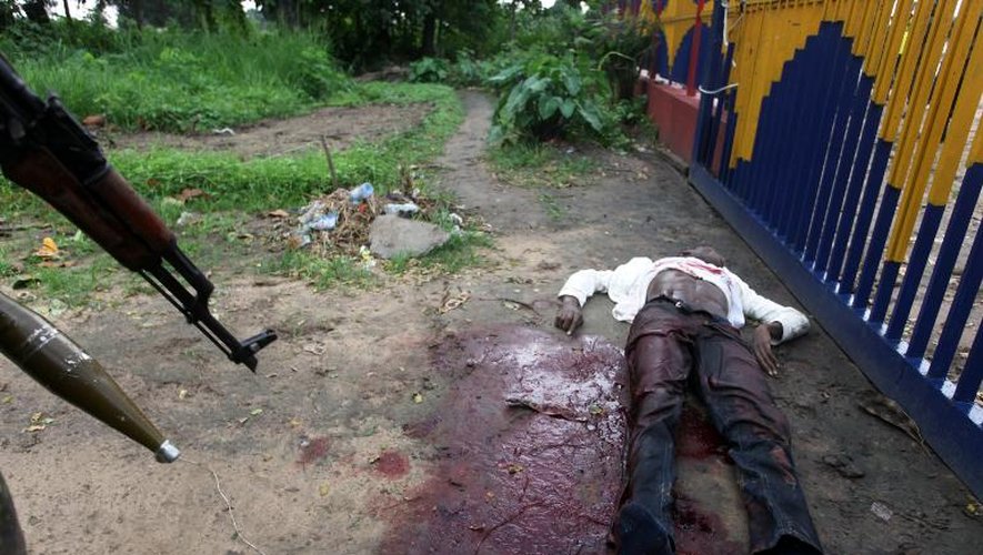 Le corps d'un homme, soupçonné d'avoir pris des journalistes en otage au siège de la télévision nationale, gît au sol, le 30 décembre 2013 à Kinshasa