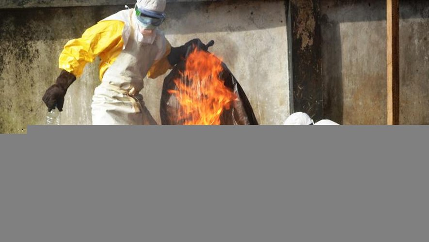 Des agents sanitaires brûlent du matériel de protection usagé au centre de Médecins sans frontière, le 13 septembre 2014 à Conakry