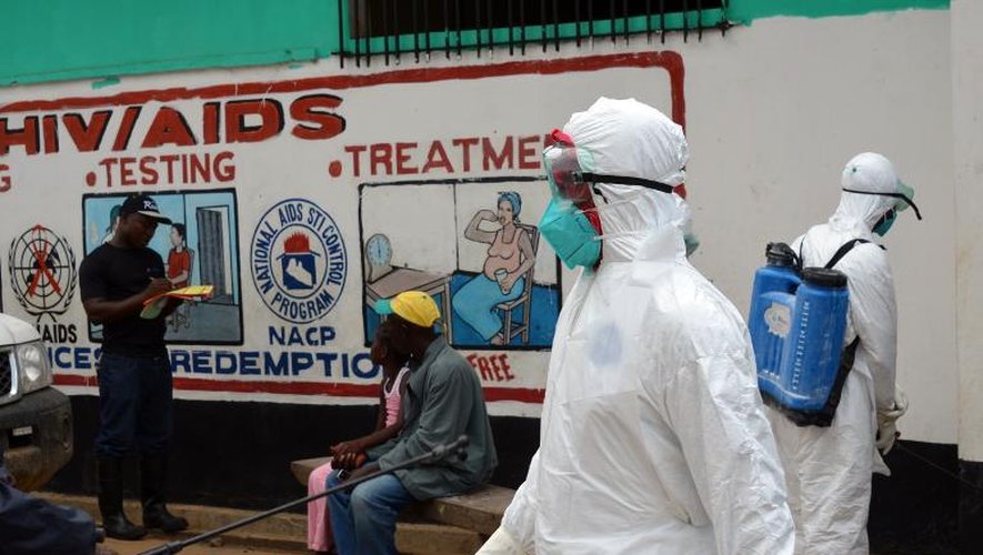 Des membres de la Croix-Rouge libérienne procèdent à une opération de désinfection dans un quartier de Monrovia touché par le virus Ebola, le 12 septembre 2014