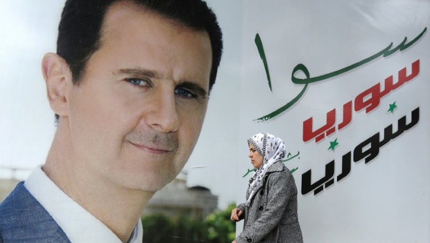 Une femme syrienne passe devant un portrait du président syrien Bashar al-Assad, à Damas, le 4 mars 2015
