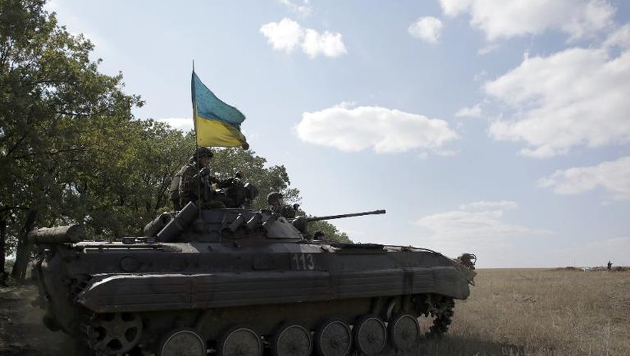 Des soldats ukrainiens juchés sur leur char, le 17 septembre 2014, près de la ville de Pervomaisk, dans la région de Lougansk