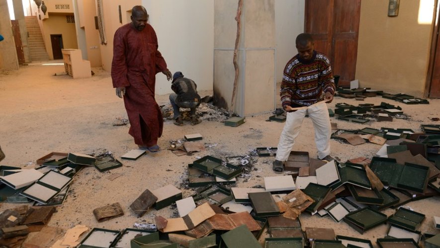 Des habitants de Tombouctou recueillent des documents anciens brûlés par les islamistes au Centre de documentation et de recherche Ahmed Baba, le 29 janvier 2013 au Mali