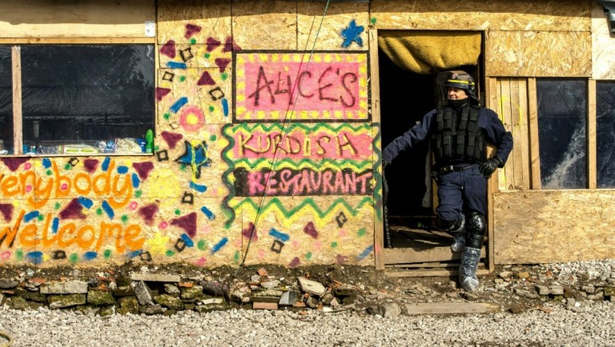 Un policier se tient devant l'entrée d'un restaurant kurde improvisé dans le jungle de Calais, le 3 mars 2016