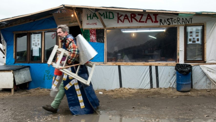 Un migrant passe devant un restaurant improvisé dans le "jungle" de Calais le 23 février 2016