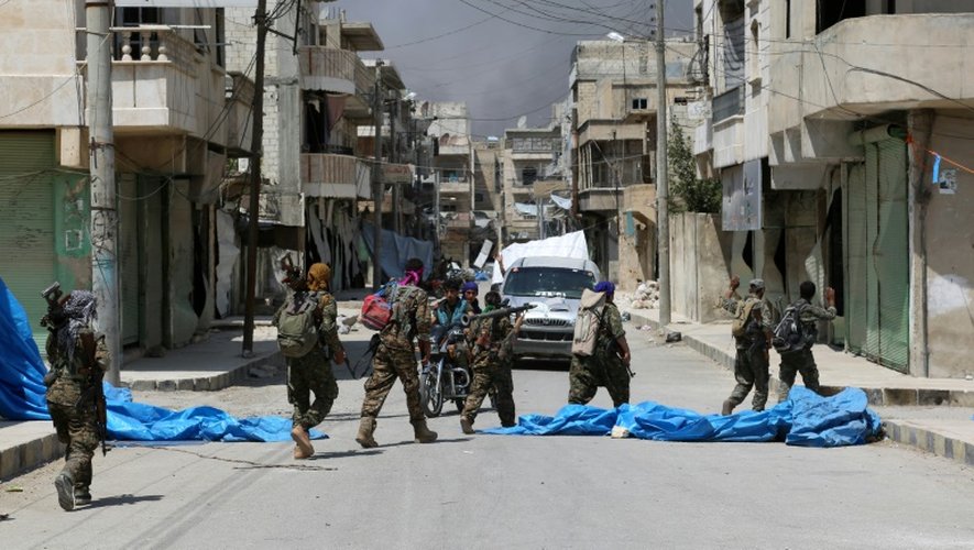 Des membres des forces démocratiques syriennes (FDS) patrouillent dans la ville de Minbej, le 7 août 2016 à la recherche de combattants de l'EI