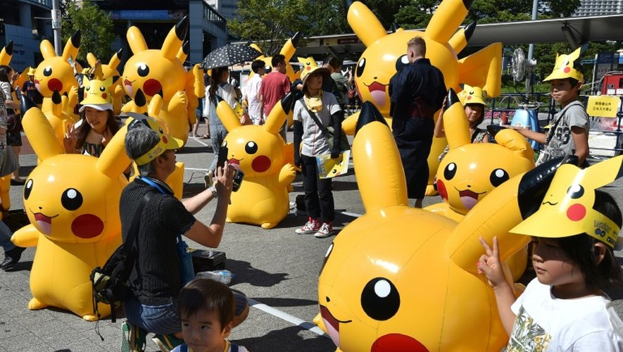 Des enfants posent au milieu d'un défilé de Pikachu à Yokohama au Japon le 7 août 2016.