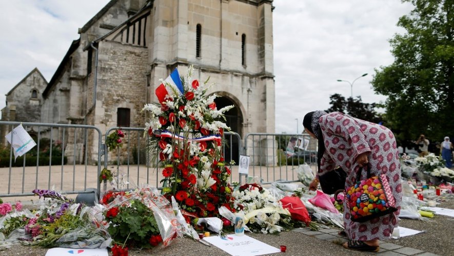 Une femme dépose des fleurs devant l'église de Saint-Étienne-du-Rouvray, le 29 juillet 2016