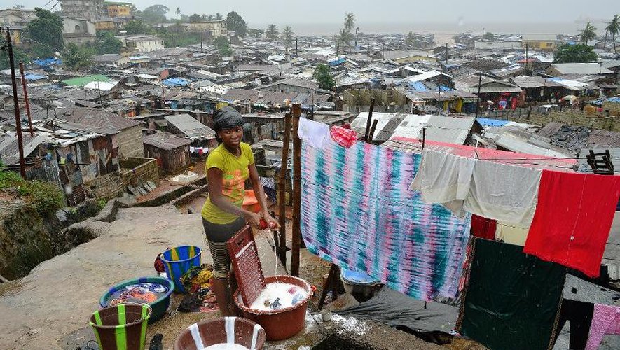 Dans le bidonville de Kroo à Freetown, une femme fait la lessive, le 13 août 2014