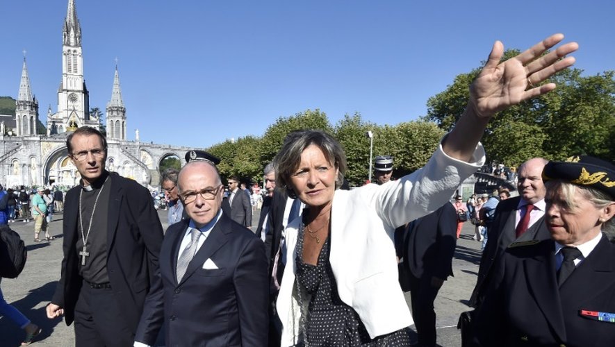 Le ministre de l'Intérieur Bernard Cazeneuve (c) entouré de l'évêque de Tarbes et de Lourdes Nicolas Brouwet (g), et de la maire de Lourdes Josette Bourdou (d), lors de sa visite à Lourdes, le 13 août 2016