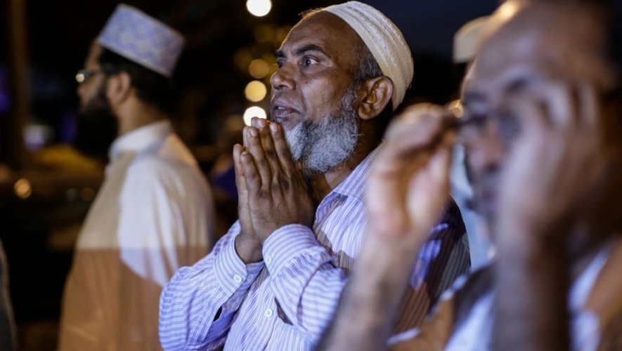 Des hommes devant une mosquée dans le quartier d'Ozone Park, à New York, où un imam et son assistant ont été abattus, le 13 août 2016