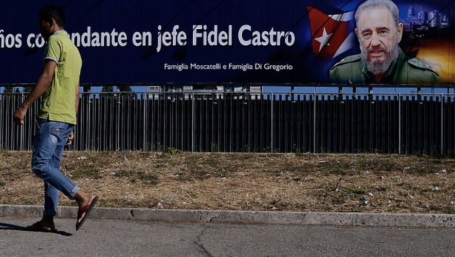Un homme passe devant une affiche accrochée à l'occasion du 90e anniversaire de Fidel Castro, le 13 août 2016 à Rome