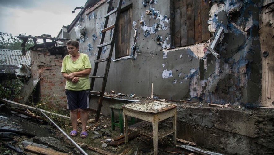 Une femme dans les décombres de sa maison le 16 août 2015 à Zolote, à l'ouest de Lougansk