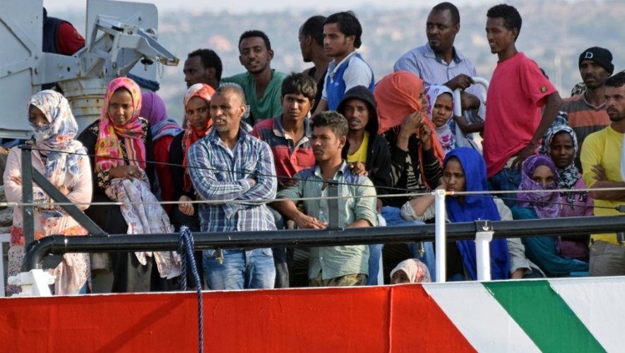 Des migrants attendent d'être débarqués d'un bateau des guardes-côtes italiens à leur arrivée le 7 auût 2015 à Pozzalo en Italie