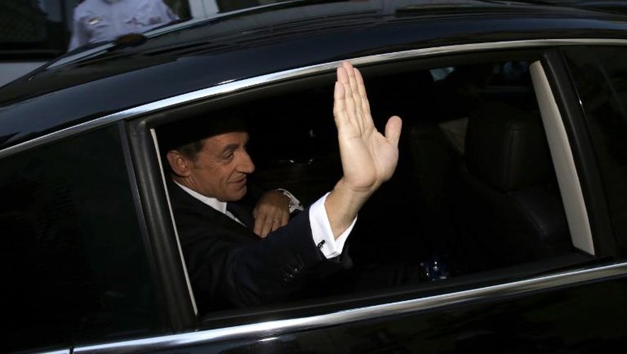 Nicolas Sarkozy fait un geste de la main alors qu'il quitte son domicile pour se rendre sur le plateau de France 2 le 21 septembre 2014