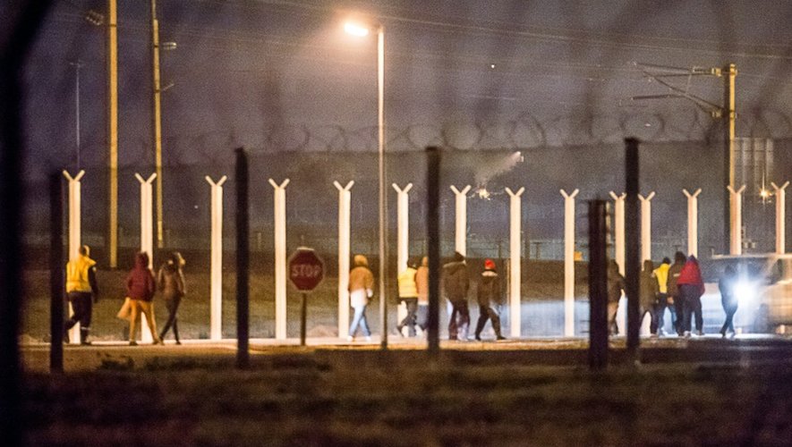 Des agents de sécurité escortent des migrants qui avaient pénétré dans le tunnel sous la Manche à Coquelles, dans le Pas-de-Calais, le 3 octobre 2015