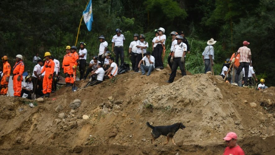 Des secouristes, pompiers et habitants sur les lieux d'un glissement de terrain à Santa Catarina Pinula, à 15 km à l'est de Guatemala, le 2 octobre 2015
