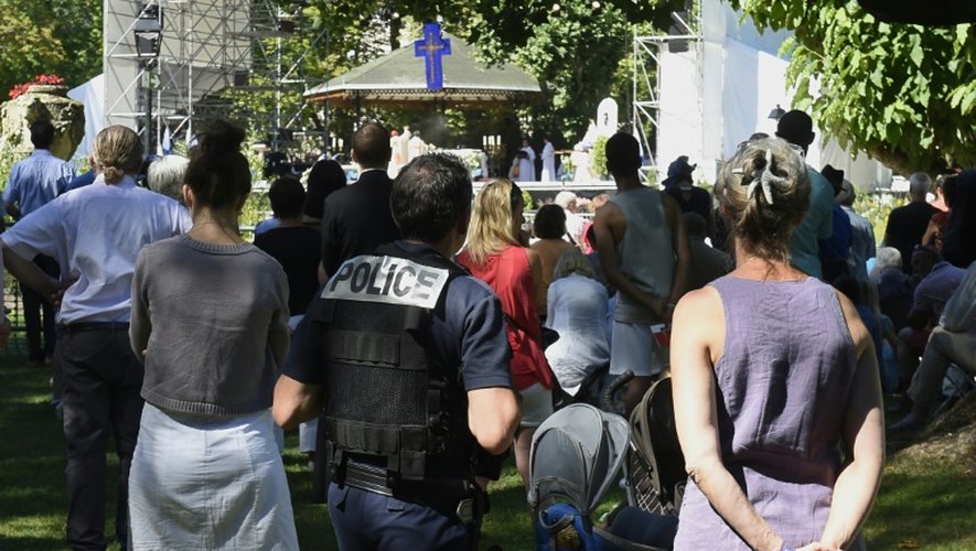 Un policier patrouille au milieu des fidèles pendant la messe de l'Assomption au Puy-en-Velay (Haute-Loire), le 15 août 2016