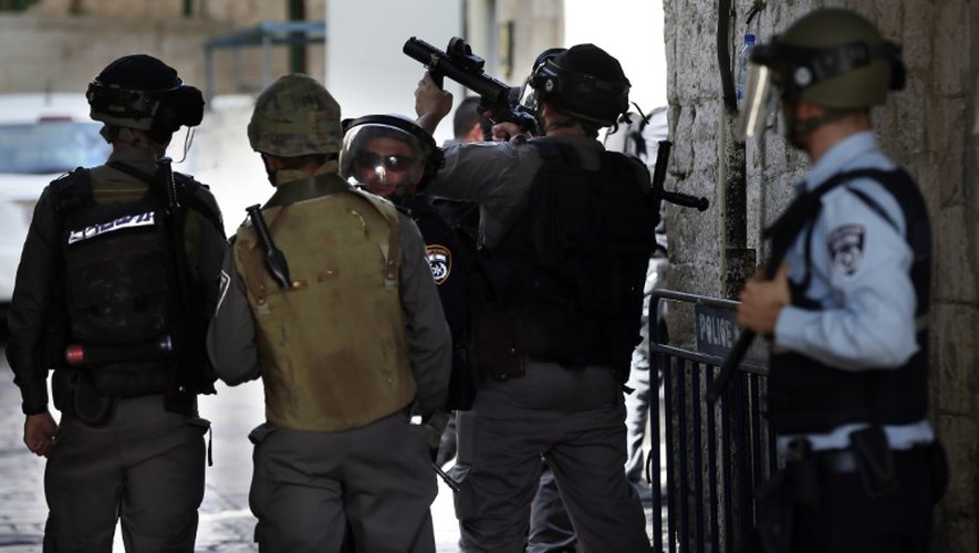 Des policiers israéliens dispersent à coups de grenades assourdissantes et de projectiles caoutchoutés des manifestants palestiniens, le 4 octobre 2015 dans la vieille ville de Jérusalem
