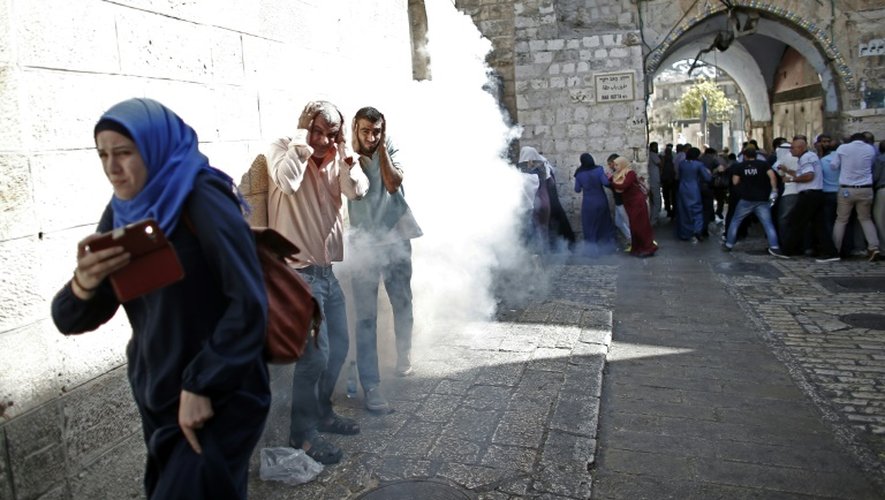 Des policiers israéliens dispersent à coups de grenades assourdissantes et de projectiles caoutchoutés des manifestants palestiniens, le 4 octobre 2015 dans la vieille ville de Jérusalem