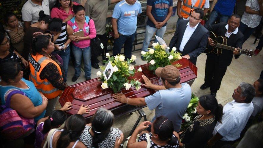 Des proches d'une jeune fille de 17 ans morte dans un glissement de terrain assistent à ses funérailles au cimetière municipal de Santa Catarina Pinula, près de Guatemala, le 3 octobre 2015