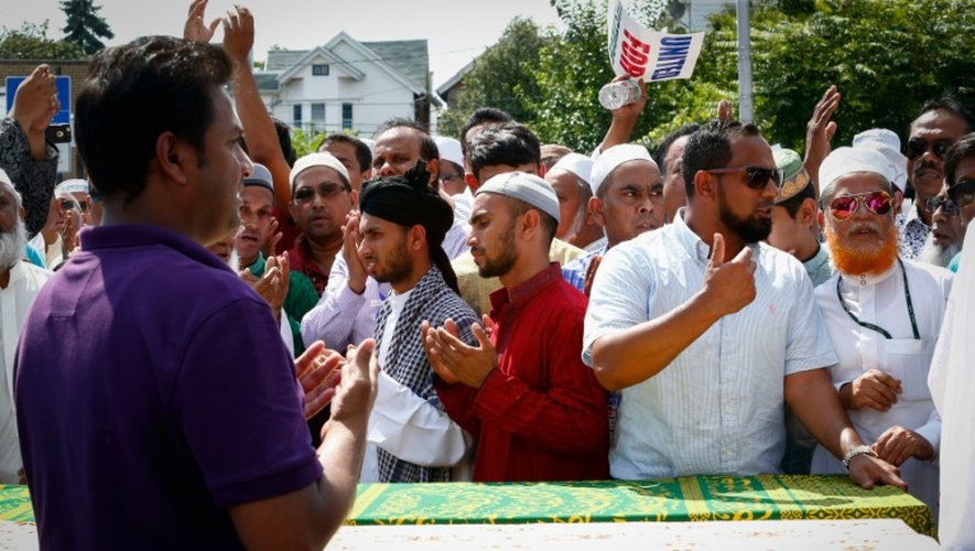 Des hommes prient autour des cercueils contenant les corps d'un imam et de son assistant tués par balles, à New York le 15 août 2016