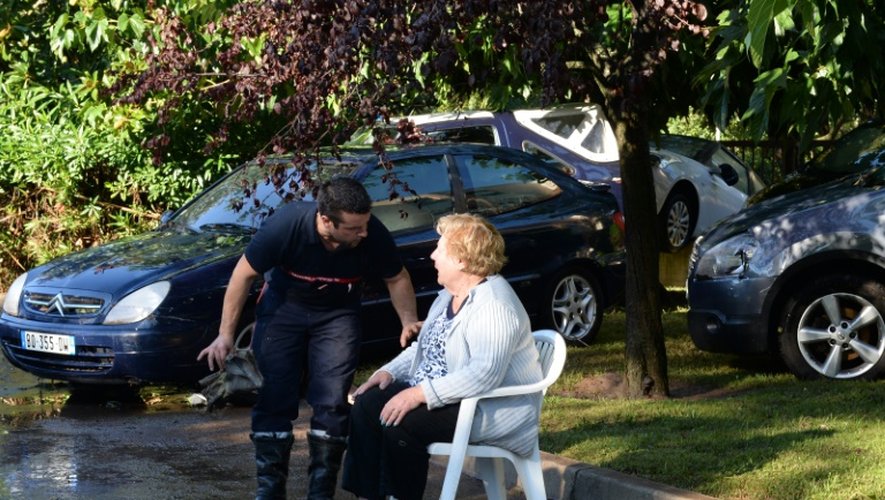 Un pompier parle à une femme choquée, victime d'inondations qui ont ravagé plusieurs résidences de Mandelieu-la-Napoule, dans les Alpes-Maritimes, le 4 octobre 2015