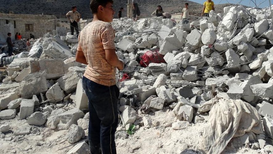 Des Syriens au milieu des décombres de leur village Kfar Derian touché le 23 septembre 2014 par les frappes de la coalition internationale