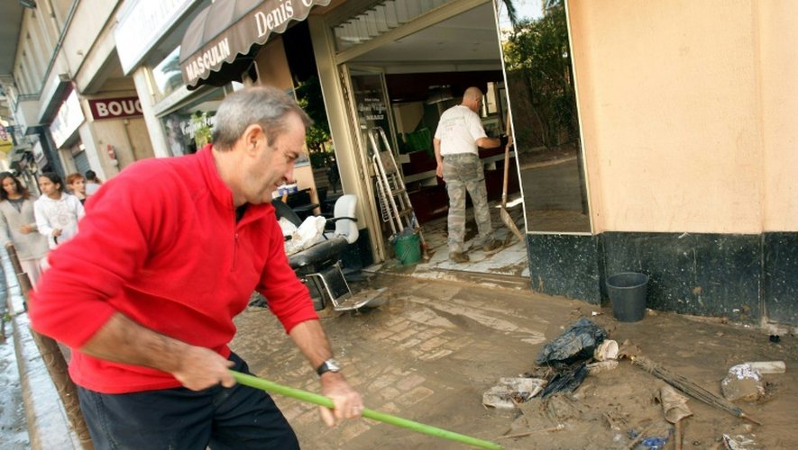 Des habitants nettoient les boutiques et trottoirs à Cannes après les inondations, le 4 octobre 20105 dans le sud-est de la France