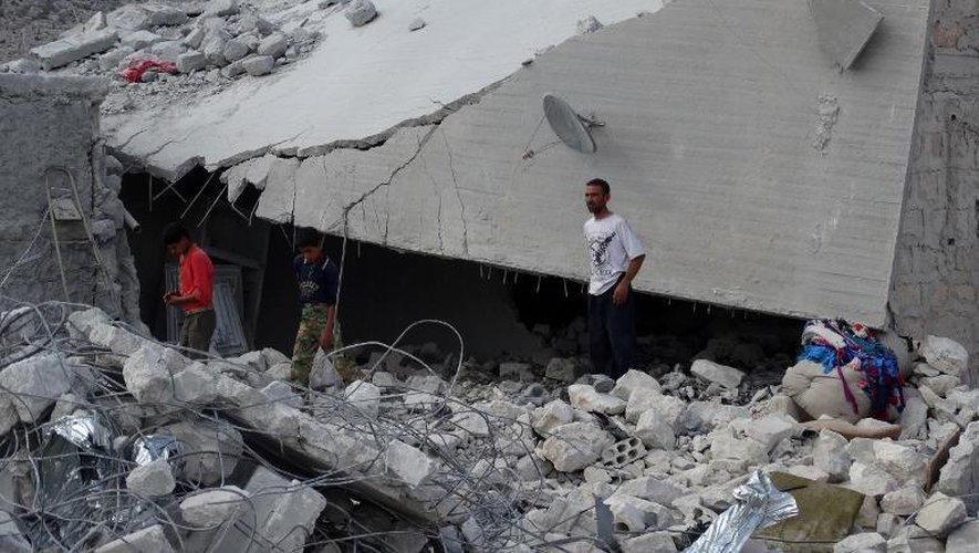 Des Syriens au milieu dans les décombres du illage Kfar Derian touché le 23 septembre 2014 par les frappes de la coalition internationale
