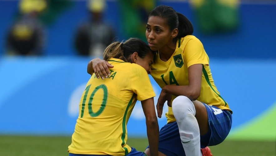 La star brésilienne Marta (g) consolée par Bruna après l'élimination par la Suède lors du tournoi de football, le 16 août 2016 à Rio