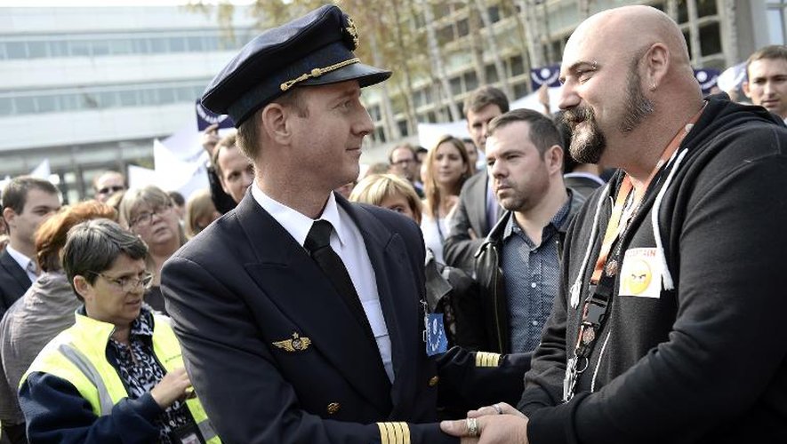 Un employé d'Air France serre à la main à un pilote lors d'une manifestation contre la grève, le 24 septembre 2014 à l'aéroport de Roissy-Charles-de-Gaulle